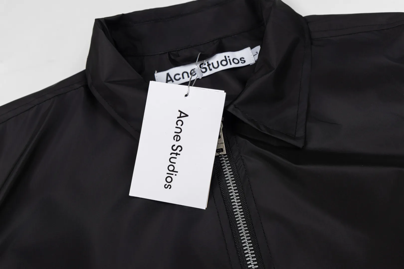140 Acne Studios Lapel Coach Jacket Glossy nylon back lettering loose windproof jacket Classic lapel coach jacket version, STOCKHOLM back logo, Nordic simple style High-density glossy nylon fabric, light and crisp, windproof and water-repellent, with high-end gloss Metal main zipper + side eyelet details, cuff hem elastic cuffs, lock-type windproof Simple no large print on the front chest, letters on the back as a visual highlight, suitable for street commuting Style number: ST 014# Color: Off-white Black Burgundy Size: S-XL